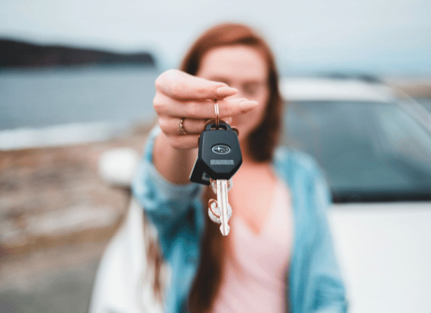 Woman holding keys to new car.